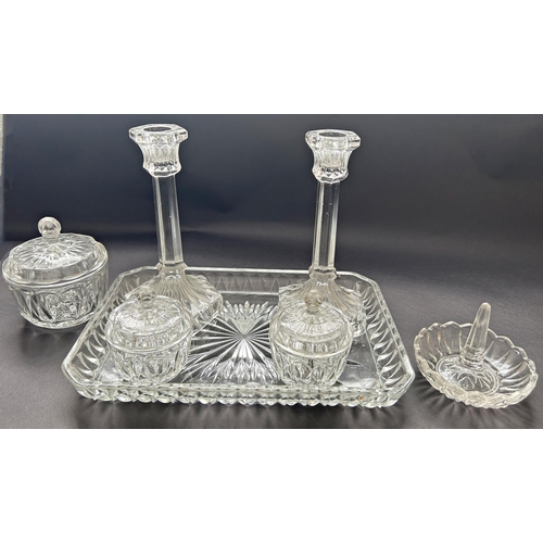 1199 - An early 20th century glass dressing table set of a pair of candlesticks, three jars, a ring stand o... 