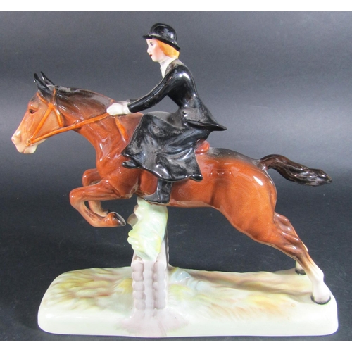 1073 - A Beswick figure of a huntswoman riding side saddle clearing a fence