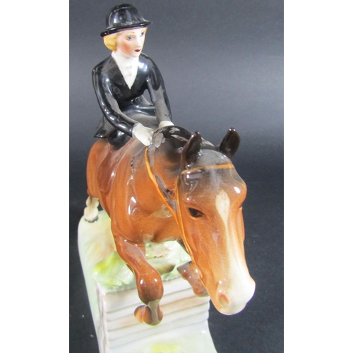 1073 - A Beswick figure of a huntswoman riding side saddle clearing a fence