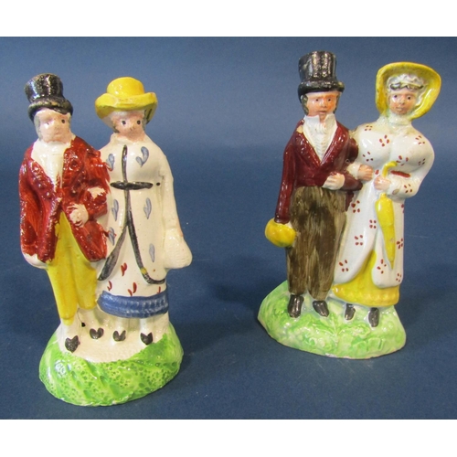 1083 - Two early 19th century Staffordshire figures, male and female with arms entwined in fashionable dres... 