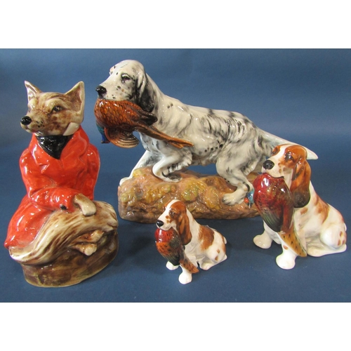 1099 - A Staffordshire pottery figure of a fox in recumbent pose dressed in a red hunting jacket, together ... 