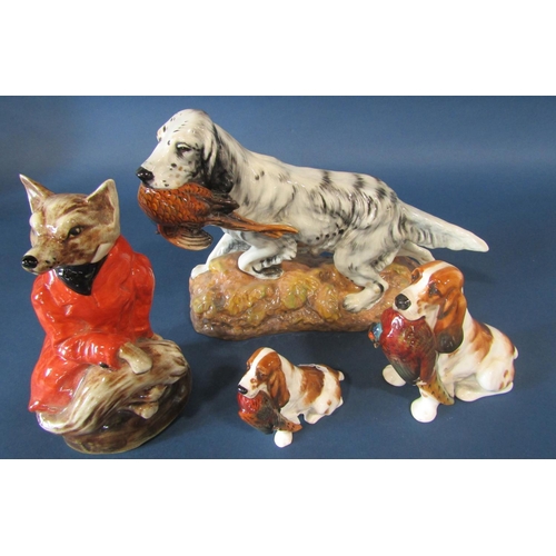 1099 - A Staffordshire pottery figure of a fox in recumbent pose dressed in a red hunting jacket, together ... 