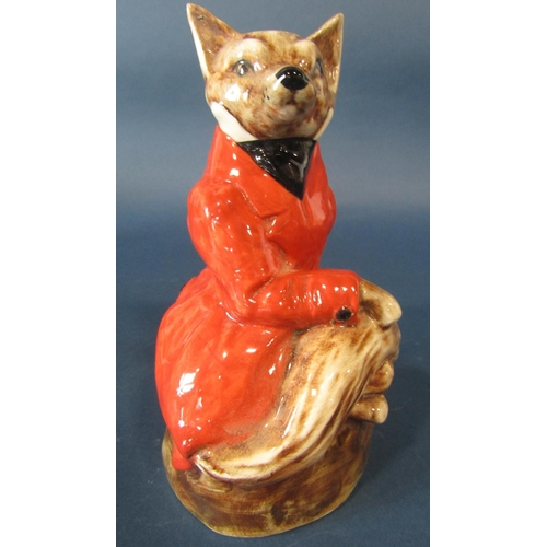 1099 - A Staffordshire pottery figure of a fox in recumbent pose dressed in a red hunting jacket, together ... 