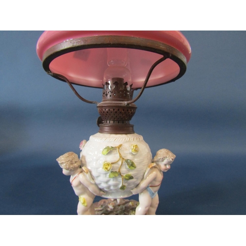 1101 - A 19th century German porcelain oil lamp, the lattice work floral encrusted reservoir supported by t... 