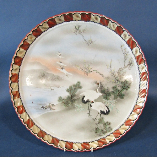 1170C - A Japanese ceramic tray, circular, the central panel cranes, prunus blossom in landscape within a re... 