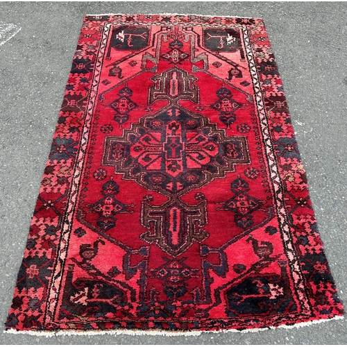 2763 - A Middle Eastern carpet with an extended central medallion on a predominantly red ground 183  cm x 1... 