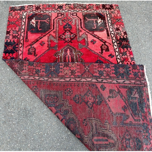 2763 - A Middle Eastern carpet with an extended central medallion on a predominantly red ground 183  cm x 1... 