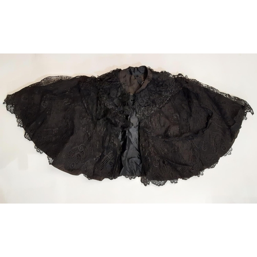 1832 - A late 19th / early 20th century shoulder cape in black patterned fabric overlaid with lace and embe... 