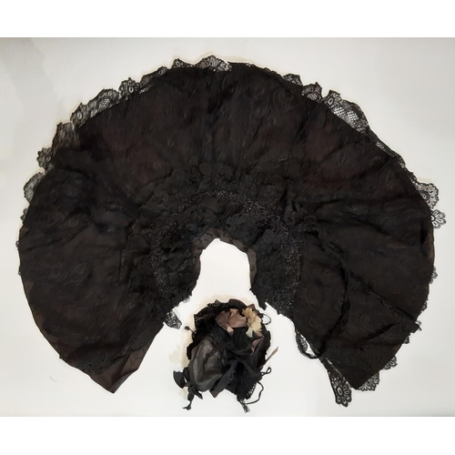 1832 - A late 19th / early 20th century shoulder cape in black patterned fabric overlaid with lace and embe... 