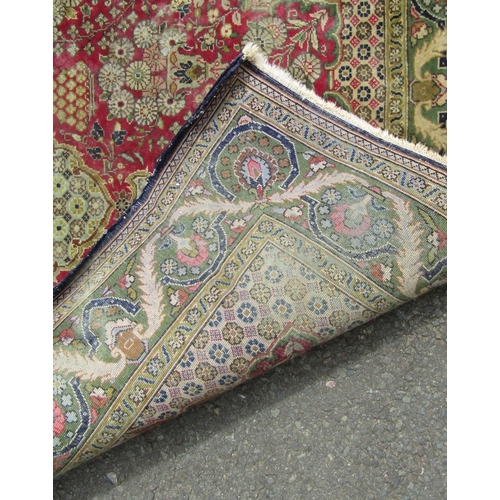 2744 - A Persian hand-knotted wool rug with vases of flowers and a scrolling floral border, in tones of cri... 