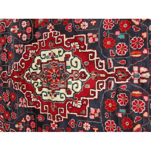 2745 - A North-west Persian Sarouk Rug, with an overall floral design predominantly in blue and red with ar... 