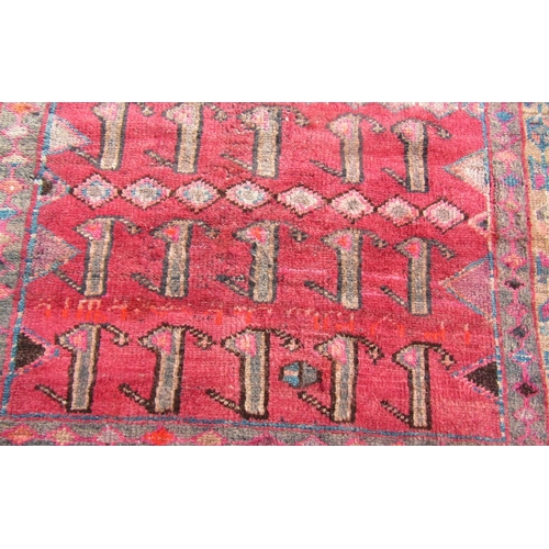 2749 - A Persian rug with multiple rows of stylised animals in red, pink and brown tones, 280 x 138 cm