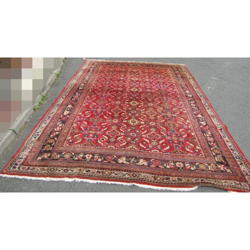 2750 - A large country house Persian design Rug, hand-knotted with repeated floral pattern on a red ground,... 