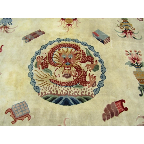 2752 - A large Chinese rug with central dragon medallion and motifs of lotus flowers, censers, urns and scr... 