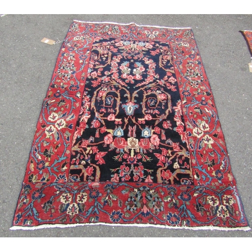 2756 - A Persian rug with all-over floral design, visible areas of repair and restitching, in dark blue and... 