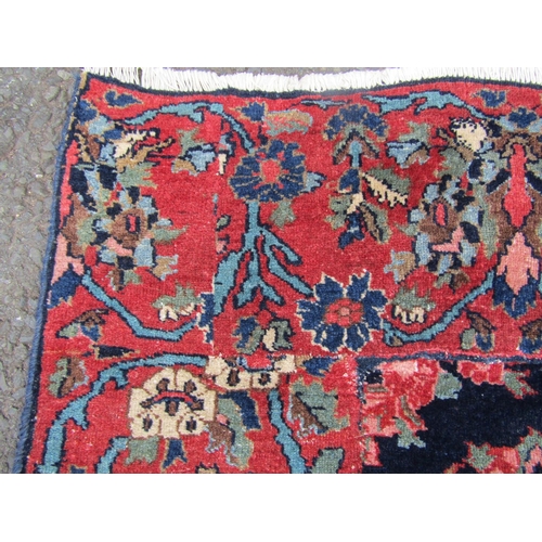 2756 - A Persian rug with all-over floral design, visible areas of repair and restitching, in dark blue and... 