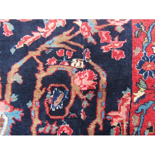 2756 - A Persian rug with all-over floral design, visible areas of repair and restitching, in dark blue and... 