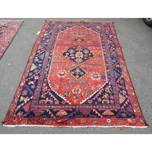 2757 - A Persian rug with central medallion and flower and branch motifs, in dark red, orange and navy tone... 