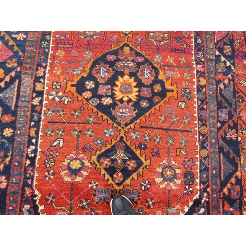 2757 - A Persian rug with central medallion and flower and branch motifs, in dark red, orange and navy tone... 