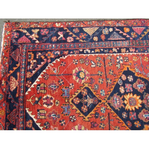 2757 - A Persian rug with central medallion and flower and branch motifs, in dark red, orange and navy tone... 