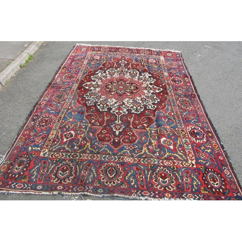 2758 - An old Persian Bakhtiar rug with a central floral medallion and traditional tones, 280 x 210 cm