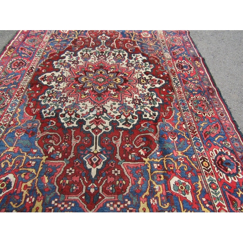 2758 - An old Persian Bakhtiar rug with a central floral medallion and traditional tones, 280 x 210 cm