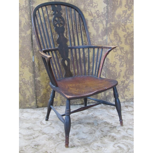 A Georgian wheelback elbow chair in elm and ash on turned supports with H shaped stretcher