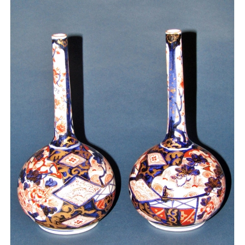 A pair of Japanese Imari vases, with bulbous bases and drawn necks, with typical decoration, 23cm high