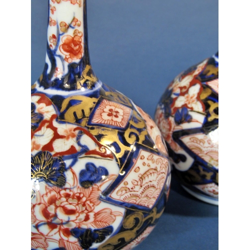 1062 - A pair of Japanese Imari vases, with bulbous bases and drawn necks, with typical decoration, 23cm hi... 