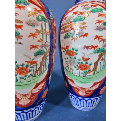 1073 - A pair of 19th century Imari shouldered vases with typical landscape and foliate detail, 25cm high