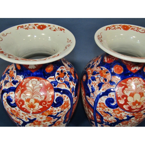 1082 - A pair of 19th century Imari vases in a red and blue colourway with repeating geometric detail, 32cm... 