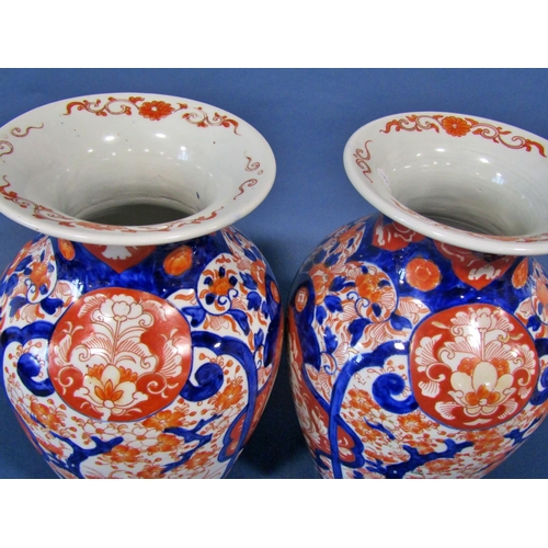 1082 - A pair of 19th century Imari vases in a red and blue colourway with repeating geometric detail, 32cm... 