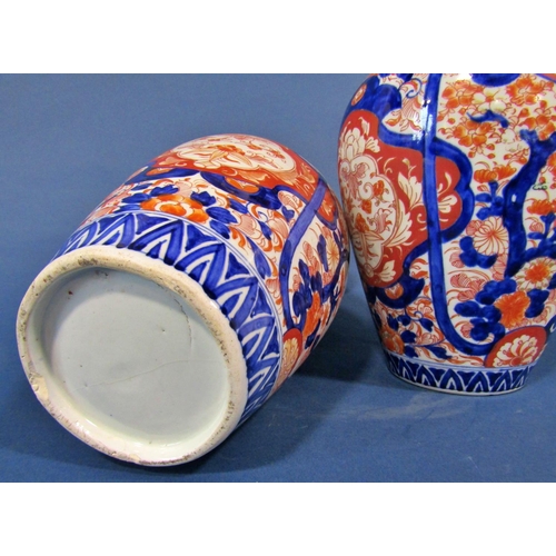 1082 - A pair of 19th century Imari vases in a red and blue colourway with repeating geometric detail, 32cm... 