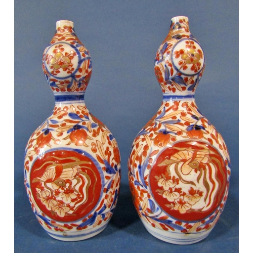 1083 - A pair of 19th century Imari gourd shaped vases with blue and red repeating floral decoration, 19cm ... 