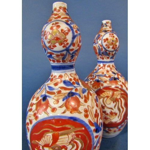 1083 - A pair of 19th century Imari gourd shaped vases with blue and red repeating floral decoration, 19cm ... 