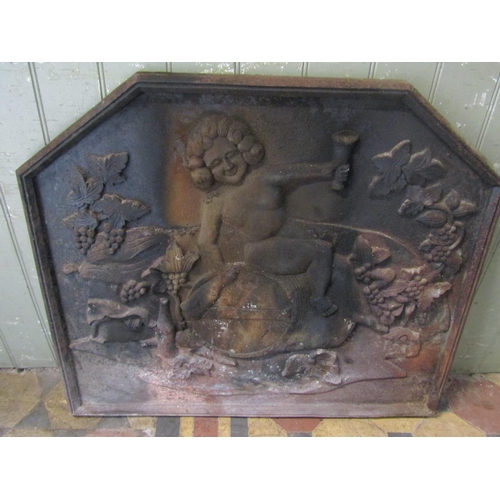 2077 - A heavy cast iron fire back with raised relief detail of a figure seated on a barrel with fruiting v... 