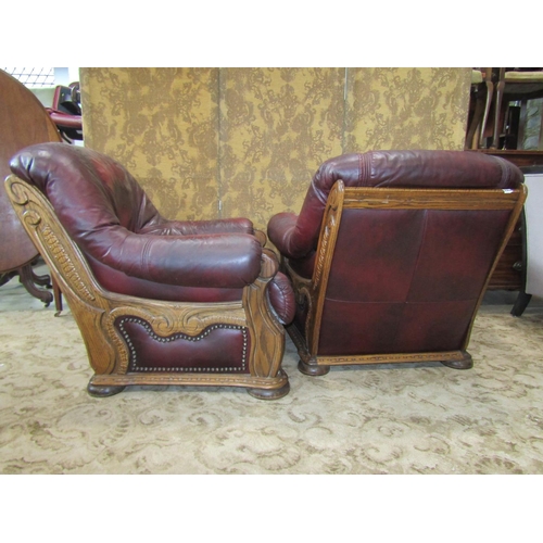 2175 - A pair of oak framed drawing room chairs with carved detail, maroon coloured upholstery