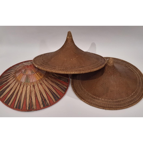 537 - A pair of oriental hats in traditional woven style diameter 57cm, together with a similar coloured h... 