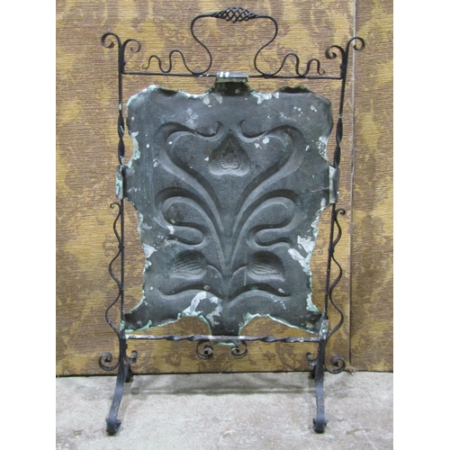 2203 - An art nouveau ironwork and hammered copper firescreen on scrolled supports