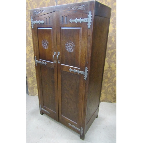 2244 - A pair old English style oak wardrobe with Tudor Rose detail, applied iron work set within a panelle... 