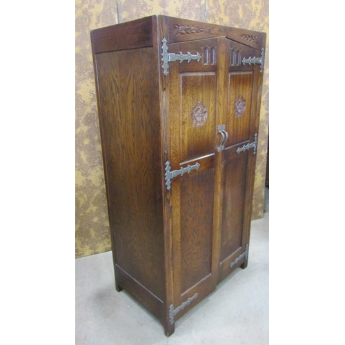 2244 - A pair old English style oak wardrobe with Tudor Rose detail, applied iron work set within a panelle... 