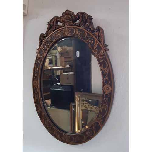 2402 - An oval gilt framed mirror in a Georgian style with acanthus, shell and other detail, 67 cm max toge... 