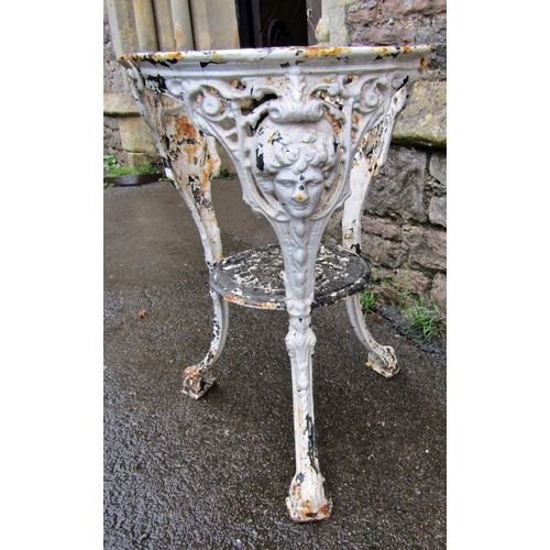 2093 - An over painted and weathered cast iron pub table base of circular form with swept supports, female ... 