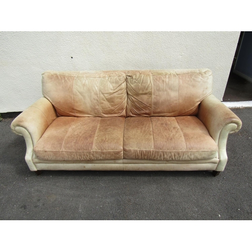 2446 - A pale leather upholstered two seater rolled arm settee raised on tapering square feet 73 cm high, 1... 