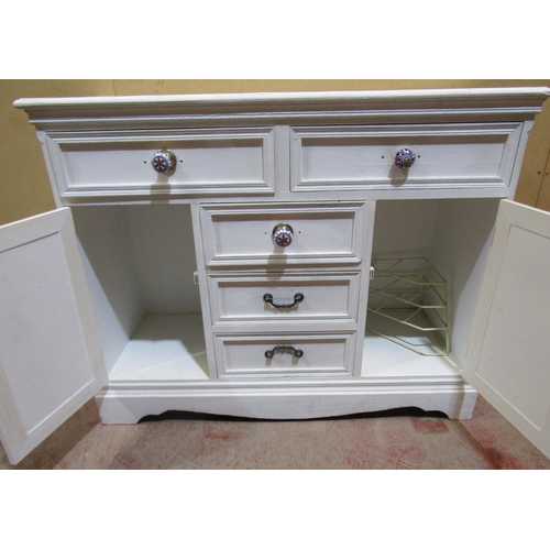 2468 - A over-painted pine chest of drawers, the base with panelled cupboard doors, fitted partially with p... 