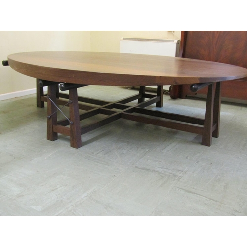 2475 - A large hardwood occasional centre table in a Japanese design, the oval top raised on eight square c... 