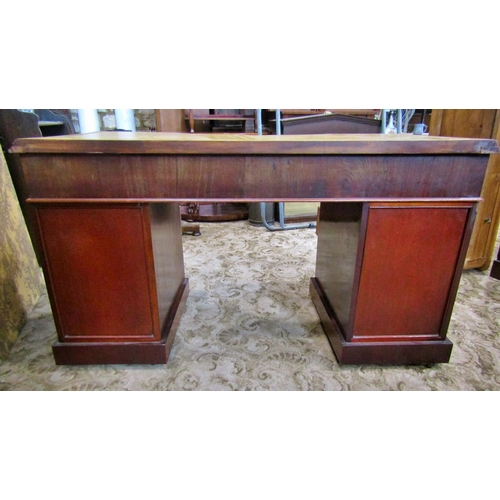 2304 - A Victorian mahogany writing desk fitted with an arrangement of eight frieze drawers, a central dumm... 