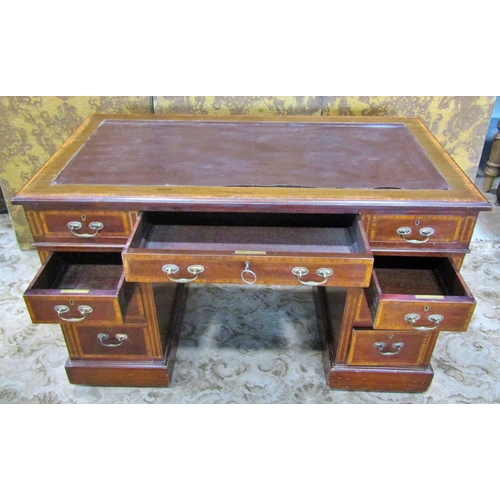 2306 - An inlaid Edwardian mahogany kneehole writing desk crossbanded in satinwood fitted with nine drawers... 