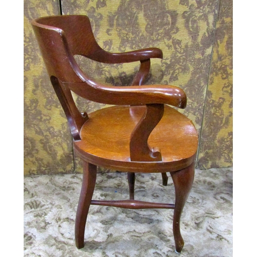 2321 - A late 19th century American oak office chair with saddle seat, carved splat back and raised on shap... 