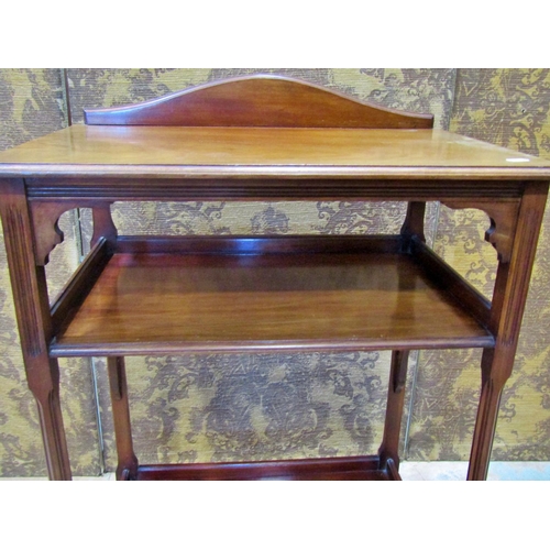 2325 - An Edwardian mahogany three tier side table with reeded column supports, 61 cm wide